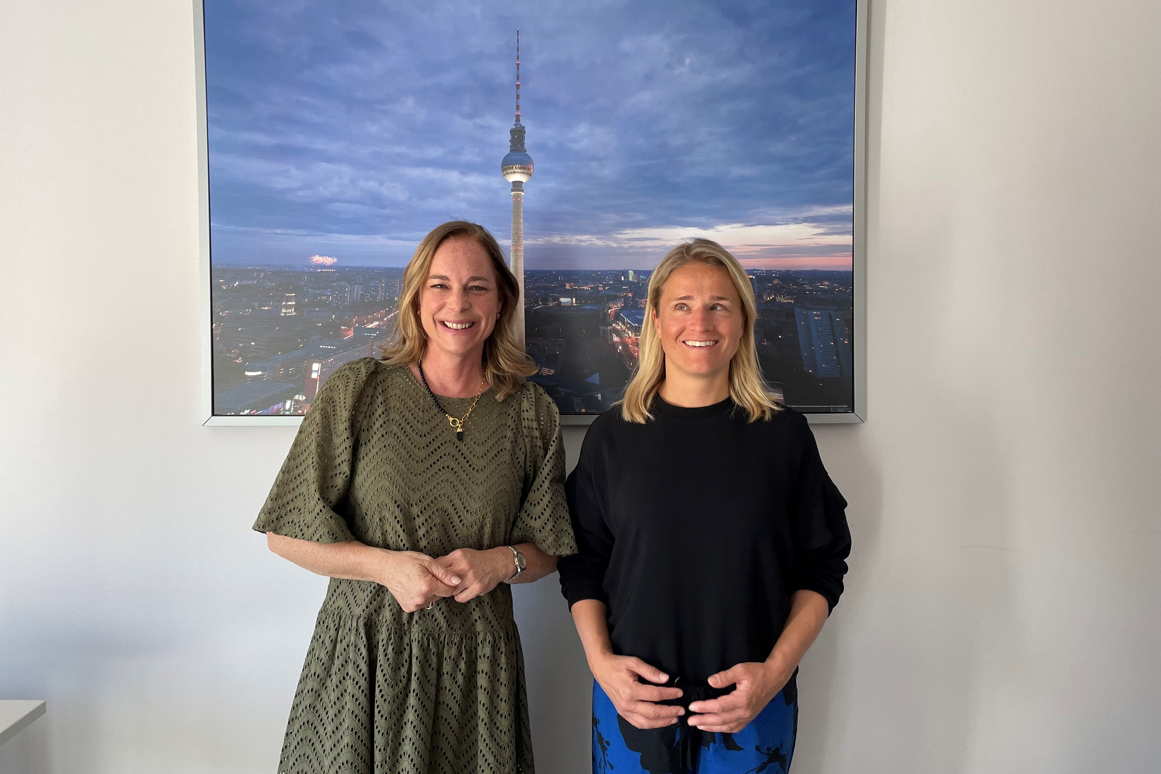 Hildegard Bentele und Verena Bentele Hildegard Bentele und Verena Bentele stehen nebeneinander. Hinter ihnen hängt ein Bild an der Wand, auf dem der Berliner Fernsehturm zu sehen ist.