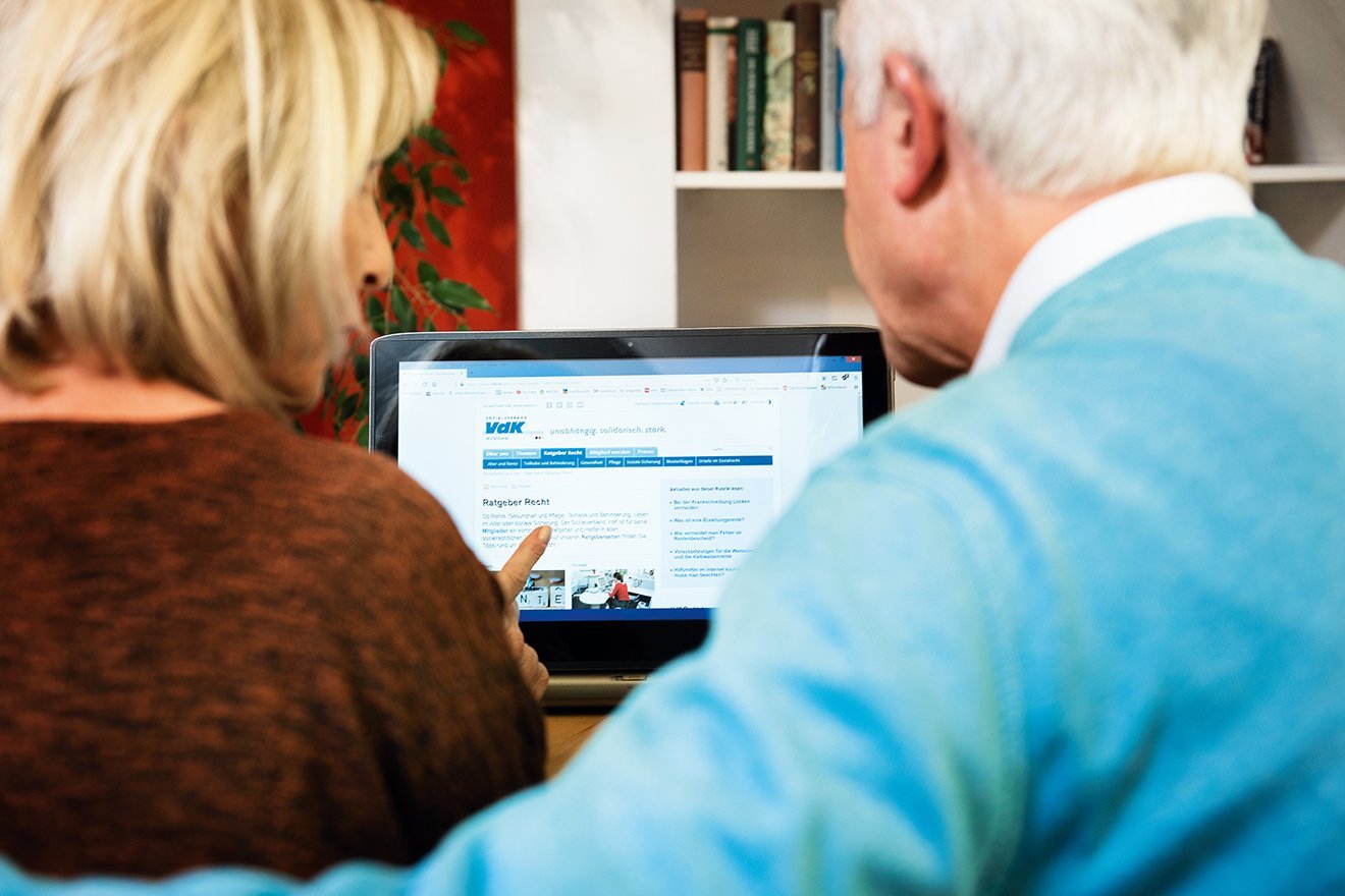 Ein &auml;lteres Paar am Computer, auf dem Bildschirm sieht man die Facebook-Seite des VdK Deutschland