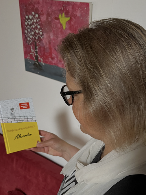 Tanja Imhoff von der Seite mit dem Kinderbuch in der Hand