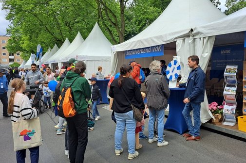 Der blau-wei&szlig;e Infostand mit Gl&uuml;cksrad und Besuchern