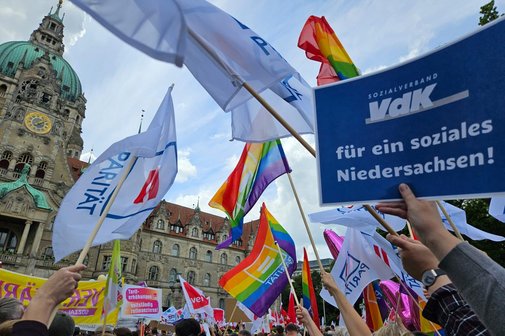 Menschen halten Fahnen und Schilder w&auml;hrend der Kundgebung am 10. Juni hoch
