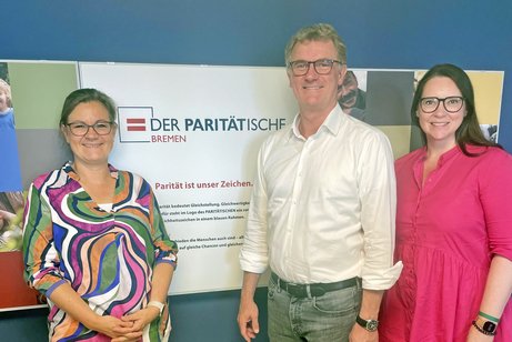 Birgitt Pfeiffer, Holger Grond und Andrea Nacke vor dem Logo des Paritätischen in Bremen
