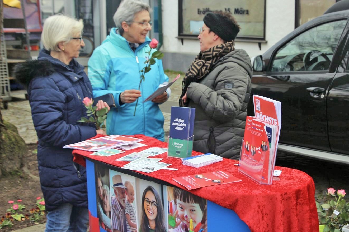 Drei Frauen im Gespräch am blau-roten VdK-Infostand auf dem Wochenmarkt in Bad Essen 
