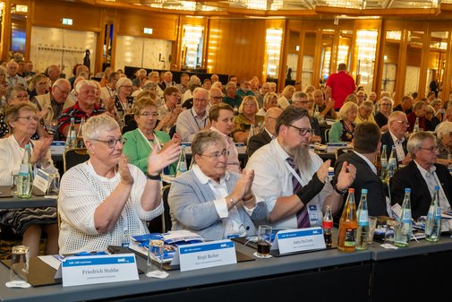 Die Delegierten an den Tischen applaudieren