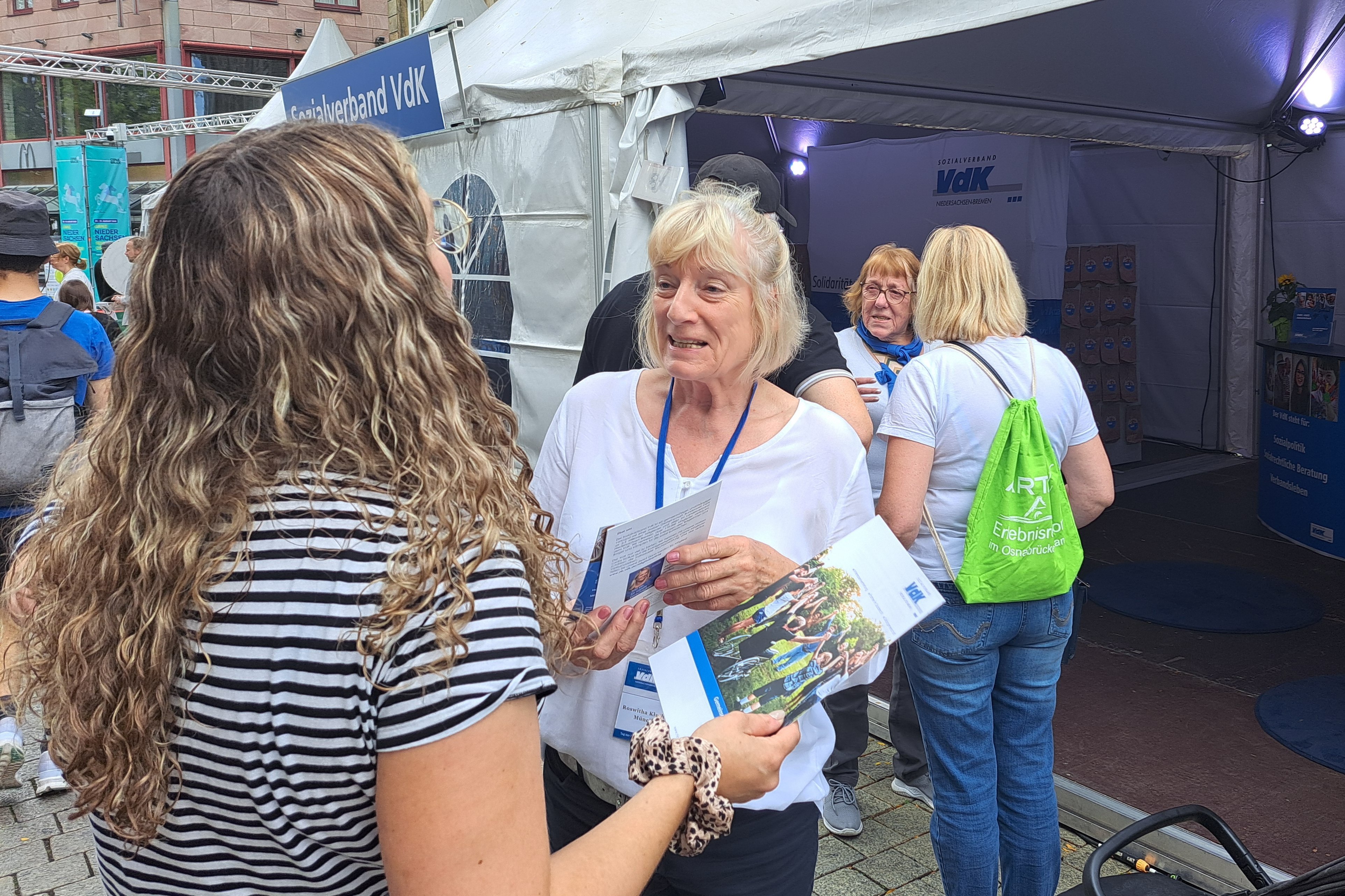 Zwei Ehrenamtliche im Gespräch mit Besuchern