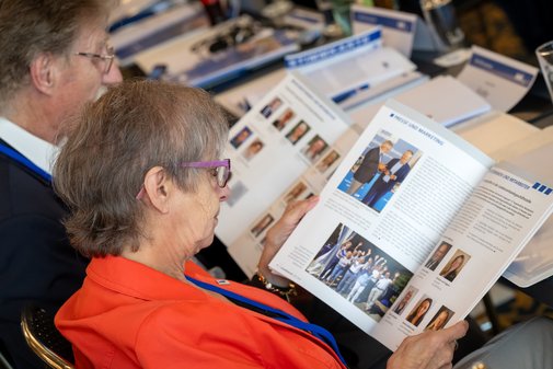 Mitglieder blättern im Geschäftsbericht