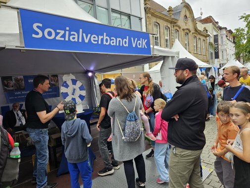 Das Glücksrad und Besucher am Infostand