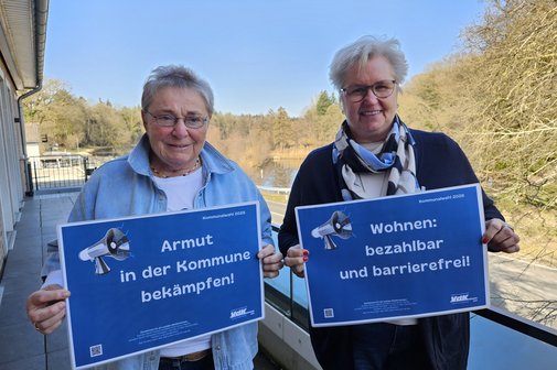 Jutta Da Corte und Birgit Ohlhoff halten l&auml;chelnd Schilder mit Forderungen hoch