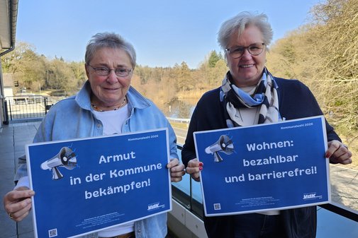 Jutta Da Corte und Birgit Ohlhoff halten l&auml;chelnd Schilder mit Forderungen hoch