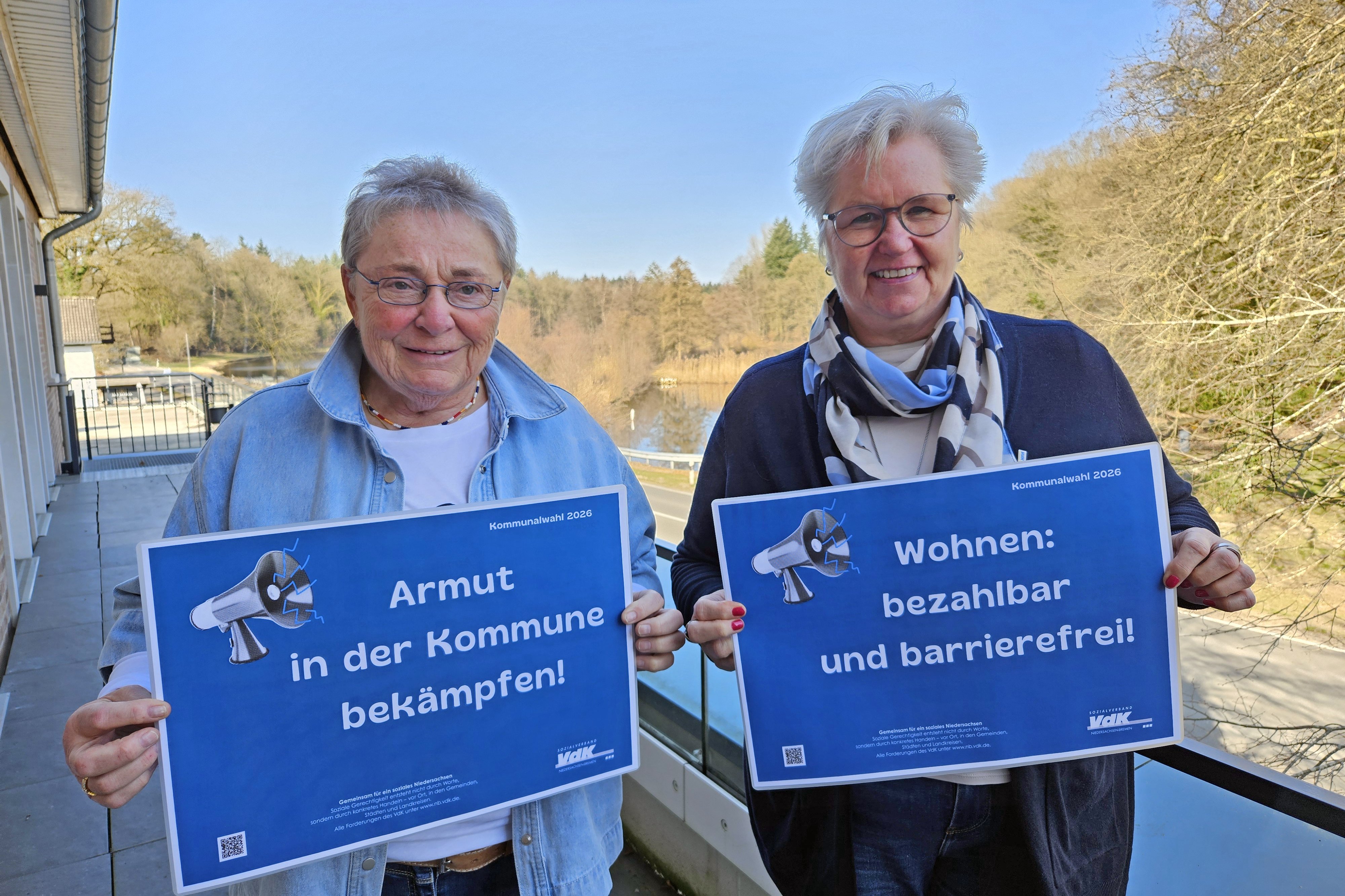 Jutta Da Corte und Birgit Ohlhoff halten l&auml;chelnd Schilder mit Forderungen hoch