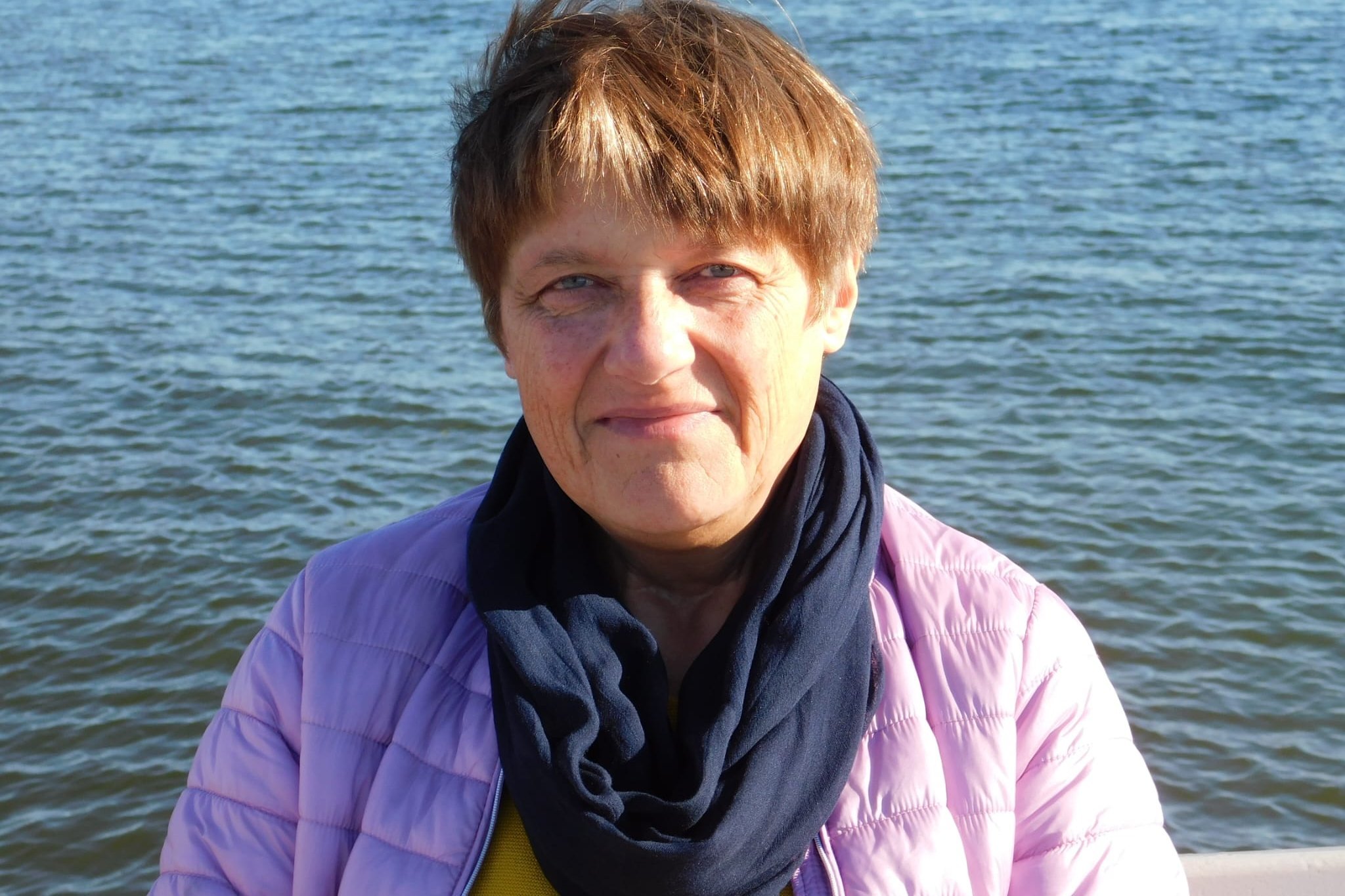 Anne Fischer mit kurzen braunen Haaren am Wasser