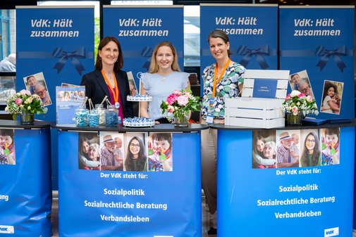 Drei Mitarbeiterinnen am blauen VdK-Willkommensstand
