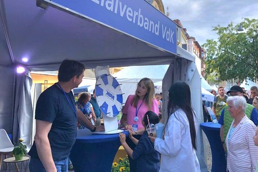 Besucher stehen in einer Schlange, um an dem VdK-Glücksrad zu drehen