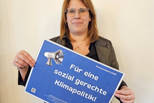 Stephanie Vrey h&auml;lt l&auml;chelnd ein Schild mit den Forderungen hoch