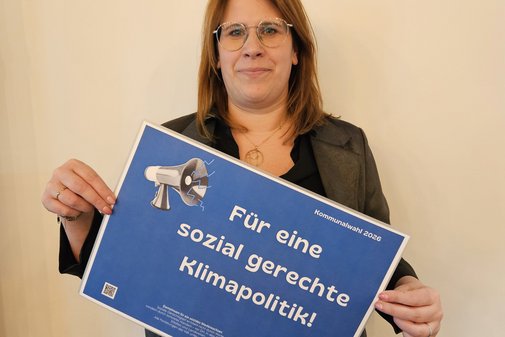 Stephanie Vrey h&auml;lt l&auml;chelnd ein Schild mit den Forderungen hoch