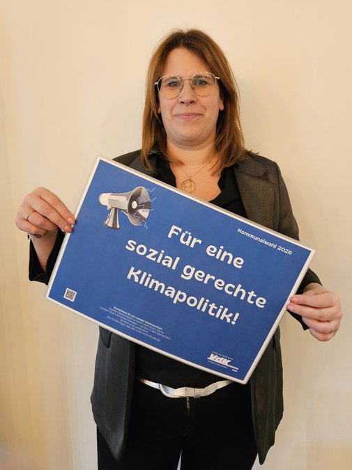 Stephanie Vrey h&auml;lt l&auml;chelnd ein Schild mit den Forderungen hoch