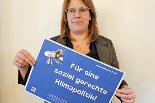 Stephanie Vrey h&auml;lt l&auml;chelnd ein Schild mit den Forderungen hoch