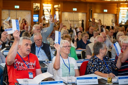 Die Delegierten in den Reihen stimmen mit Stimmzetteln ab