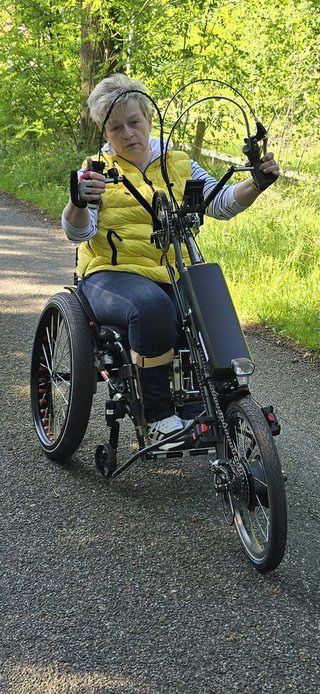 Die Frau sitzt auf ihrem Handbike und fährt