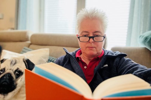 Susanne Staupendahl mit Lesebrille und Buch