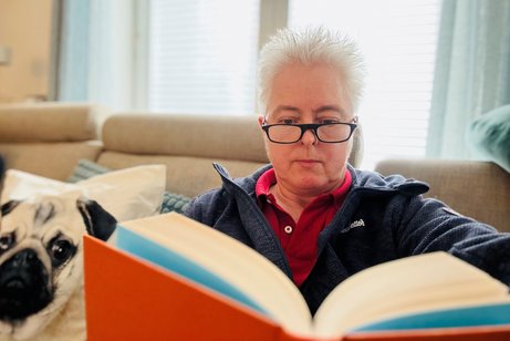 Susanne Staupendahl mit Lesebrille und Buch