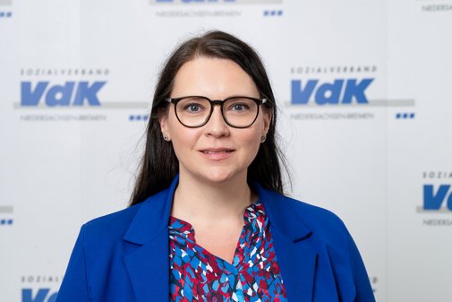 Andrea Nacke lächelnd vor dem VdK-Logo