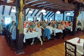 Die Mitglieder an den Tischen im Saal