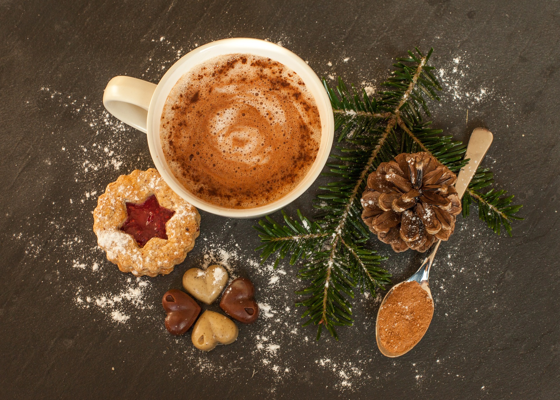 Weihnachtliches Getränk mit Keksen Ein Milchkaffee mit Keksen und einem Tannenzweig