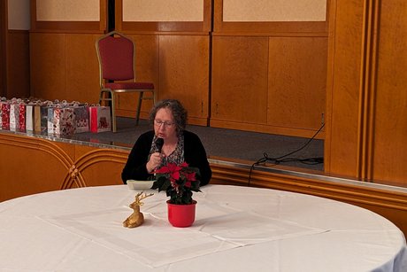 Nach dem Kaffee/Tee-Trinken wurden von unserem Vorstandsmitglied Christiane Kretzer Gedichte und Geschichten zur Weihnachtszeit vorgelesen. Sie sitzt mit Mikrofon an einem Extratisch.