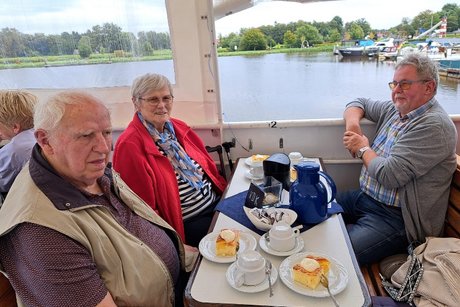 Mitglieder an Tischen auf dem Schiff