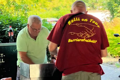 zwei M&auml;nner stehen am Grill