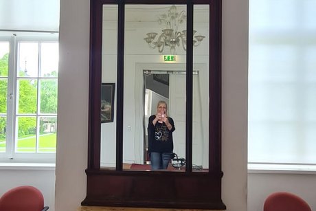 Eine Person fotografiert sich vor einem alten Spiegelschrank im Schloss Corvey