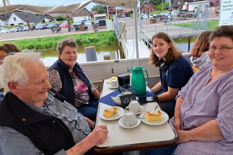 Mitglieder an Tischen auf dem Schiff