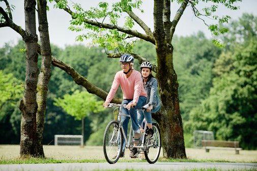 Ein &auml;lterer Mann und eine Teenagerin fahren gemeinsam auf einem Tandem.