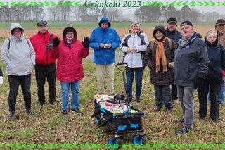 Warm angezogene Grünkohlwandergruppe mit Bollerwagen auf freiem Feld