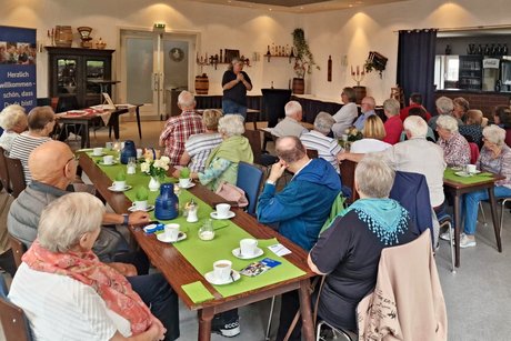 Die Mitglieder des VdK Celle-Altstadt sitzen an Tischen und h&ouml;ren Christiane Gentzmann vom DRK Kreisverband Celle e.V. zu. Sie h&auml;lt einen Vortrag &uuml;ber Erste Hilfe im Alter.
