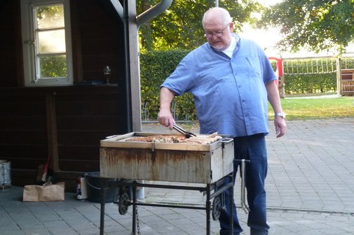 Hermann Stiegemeyer, stellvertretender Vorsitzender steht am Grill und dreht das Fleisch