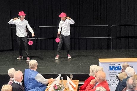 Zwei junge Artisten stehen auf der Bühne und zeigen spielerisch ihre Fähigkeiten beim Umgang mit Diabolos