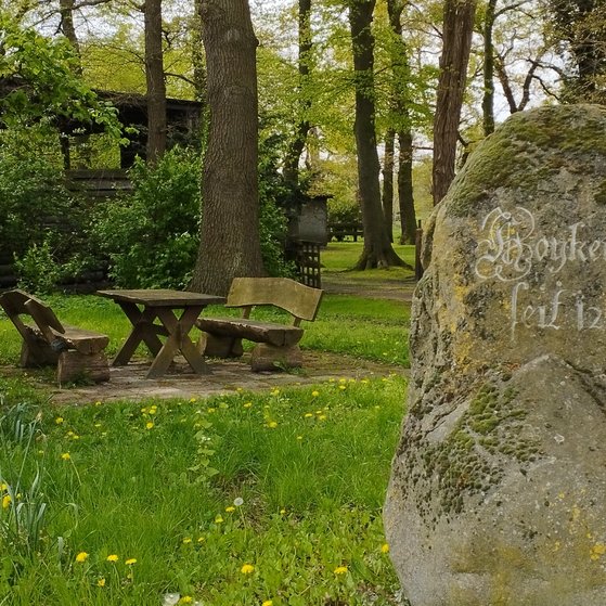 Findling in Hoykenkamp mit Schriftzug und Sitzgruppe