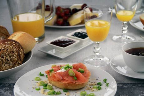 Fr&uuml;hst&uuml;cksgedeck mit Br&ouml;tchen, Kaffee und Orangensaft
