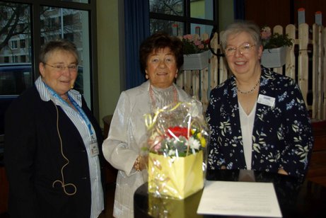 Frau Da Corte, Frau Friedrichs und Frau Müller stehen zusammen am Stehpult
