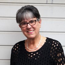 Eine &auml;ltere Frau mit dunklen Haaren, Brille und einem schwarzen Pullover