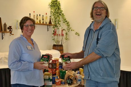 Unser Erntedanktisch Jutta Dittel von der Bahnhofsmission Celle und Matthias Krüger stehen vor dem Tisch, auf dem die Spenden der VdK-Mitglieder für die Bahnhofsmission stehen.