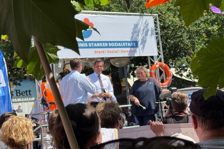 Der nieders&auml;chsische Ministerpr&auml;sident Olaf Lies h&auml;lt eine Rede auf einer B&uuml;hne. Rechts davon steht Kerstin Tack, Vorsitzende des Parit&auml;tischen Niedersachsen.