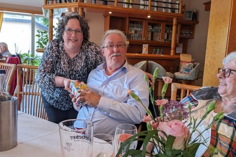 Ein Gewinner beim Bingo erh&auml;lt von einer Frau des Vorstands ein kleines Pr&auml;sent &uuml;berreicht.