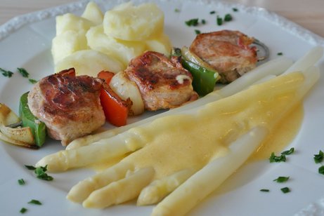 Speiseteller gefüllt mit Spargel, Blumenkohl und kleine Schnitzel