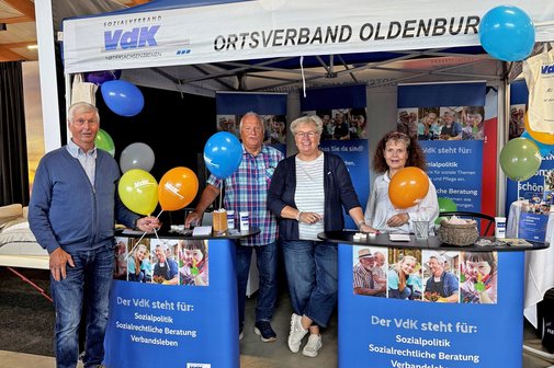 Vier ehrenamtliche Mitglieder im blau-weißen VdK-Stand