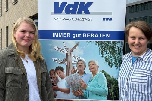 Die beiden Frauen l&auml;chelnd vor dem VdK-Logo