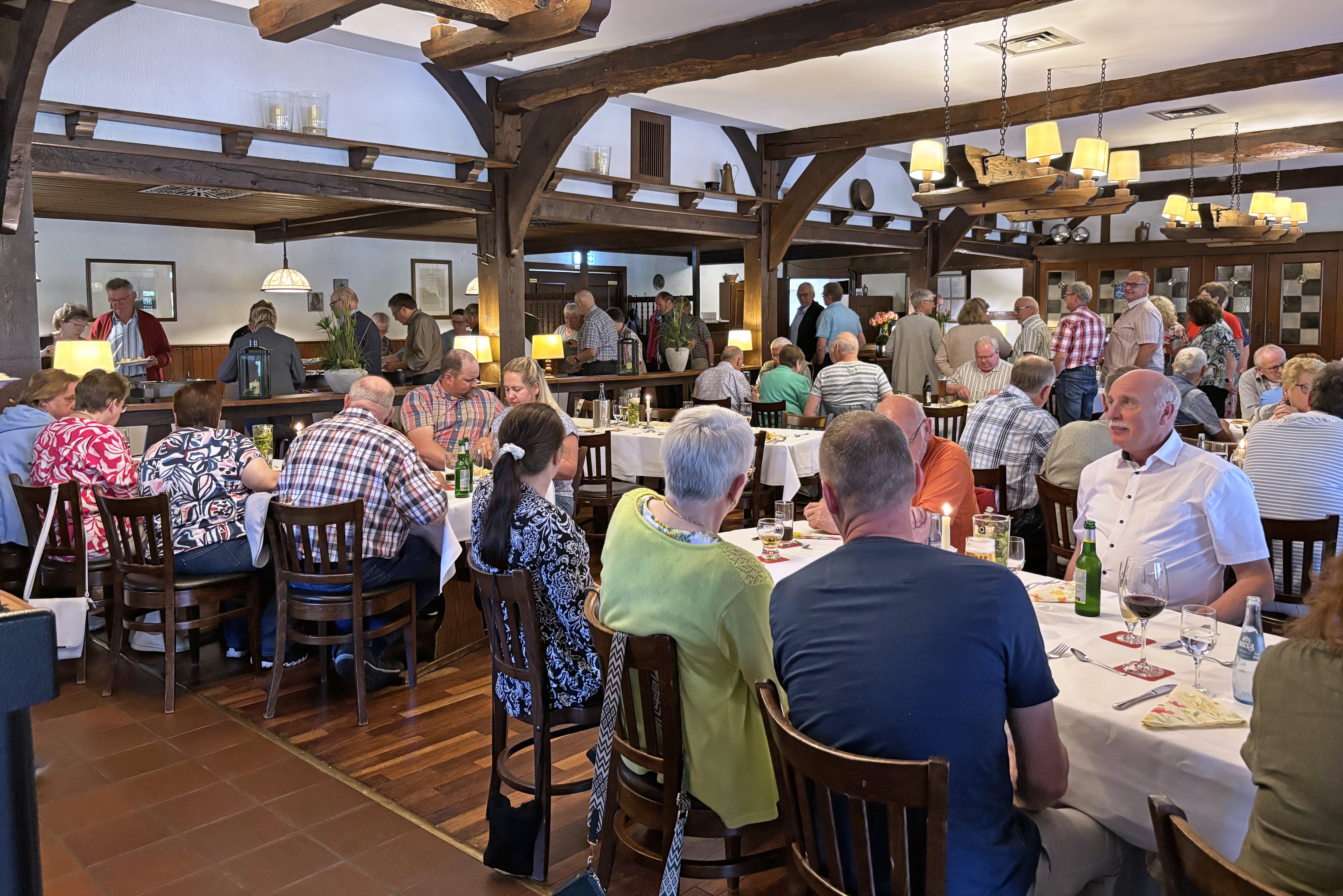 Die Mitglieder im Saal an Tischen und am Buffet