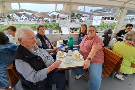 Mitglieder an Tischen auf dem Schiff